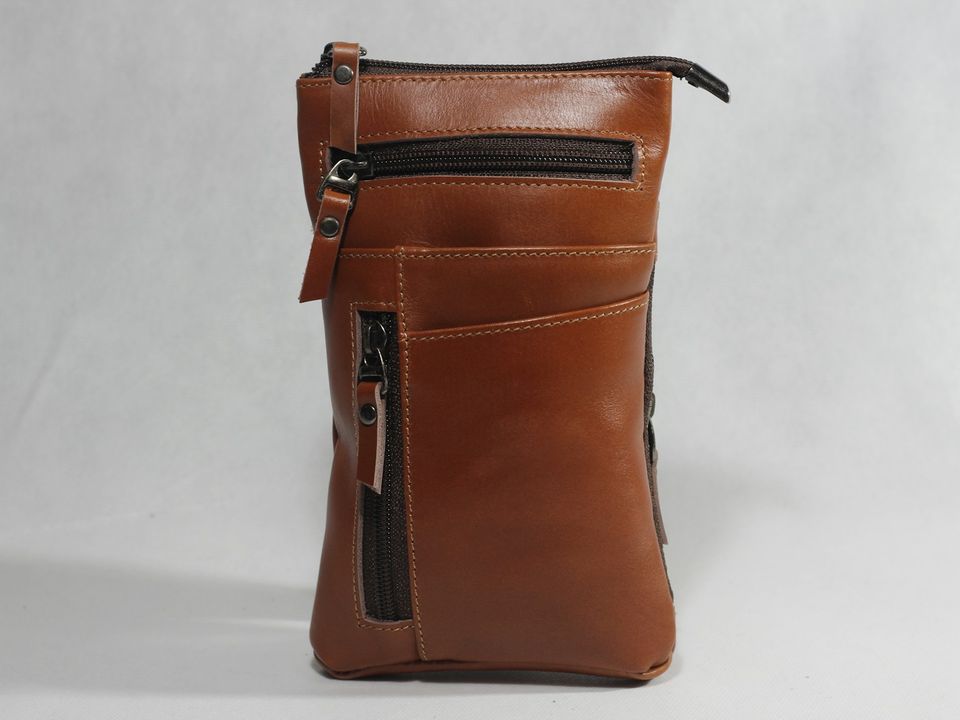 Un bolso de cuero de frente, sobre fondo liso.